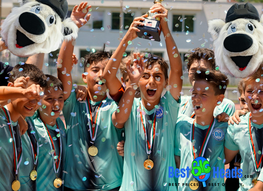 A vibrant awarding ceremony featuring a sports team celebrating their victory by waving oversized face cutouts of their team mascot. 