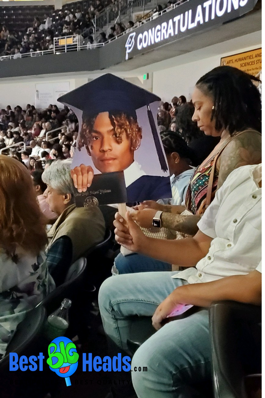 proud mom waving her son's face cutout during the ceremony